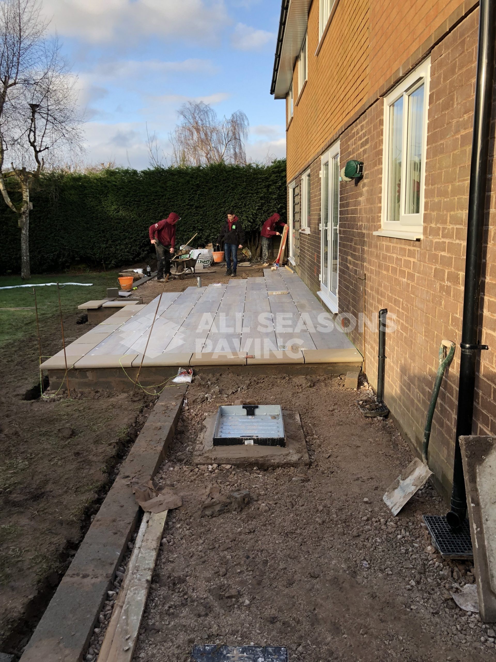 workers completing porcelain patio teak wood effect in leyland near preston
