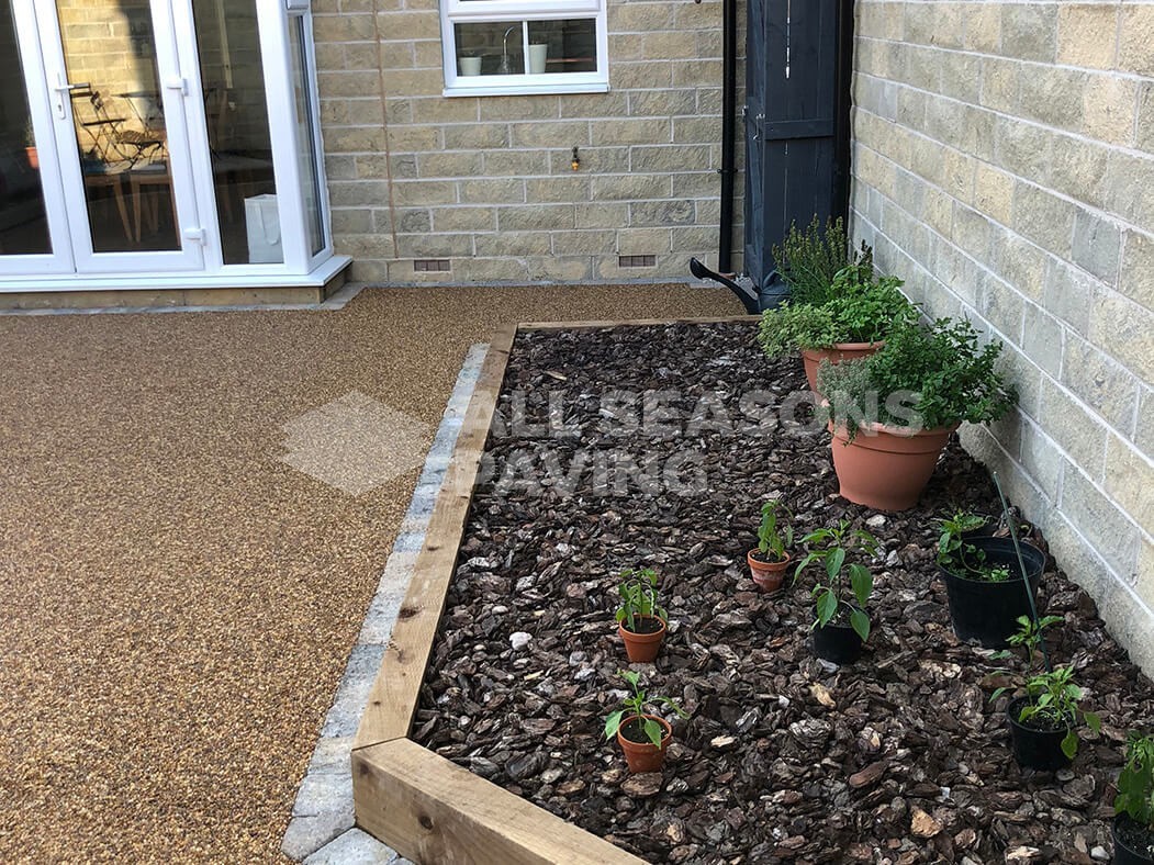 View of Resin Bound patio installed in Lancashire, near Preston with raised flower bed.